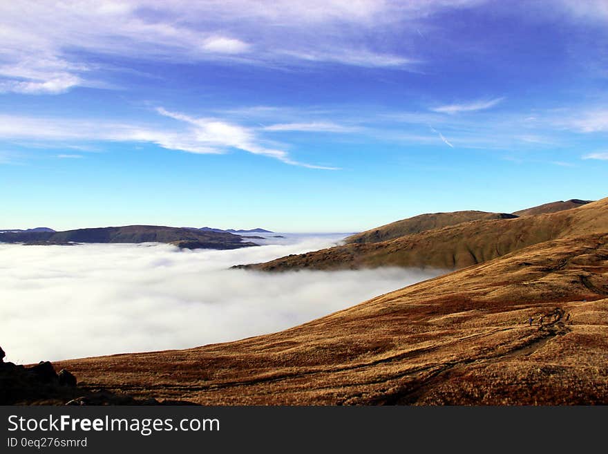 Clouds over valley with mountain peaks on sunny day. Clouds over valley with mountain peaks on sunny day.