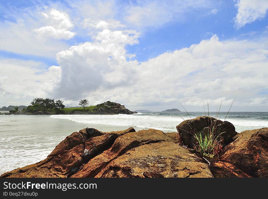 Green Island Under White Clouds and Blue Sky at Daytime