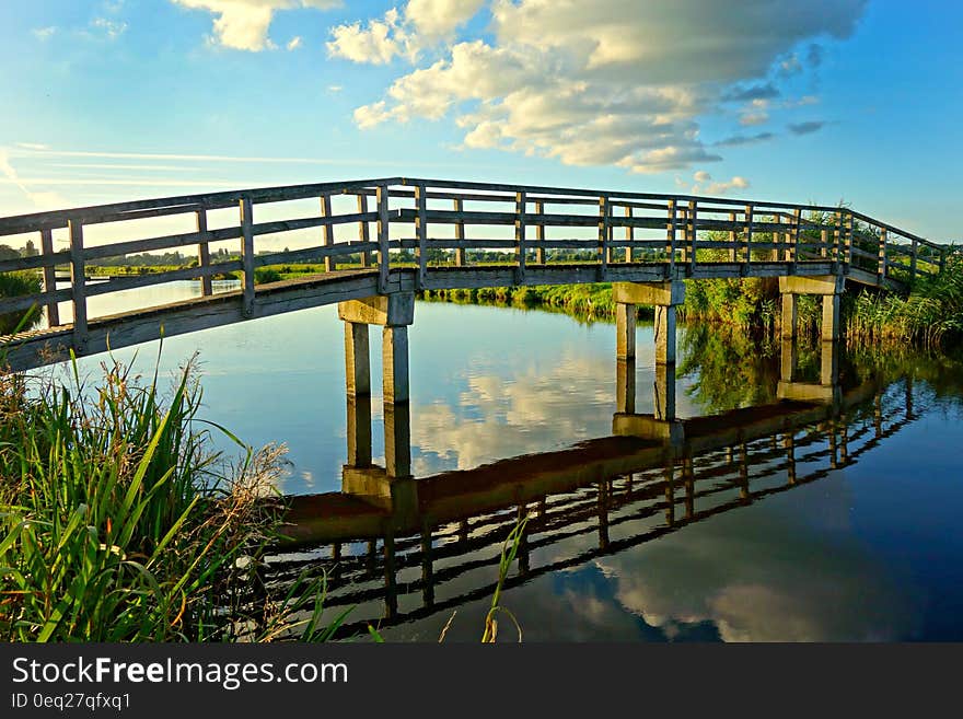 Gray Concrete Base Wooden Footbridge Between Green Grass during Daytime