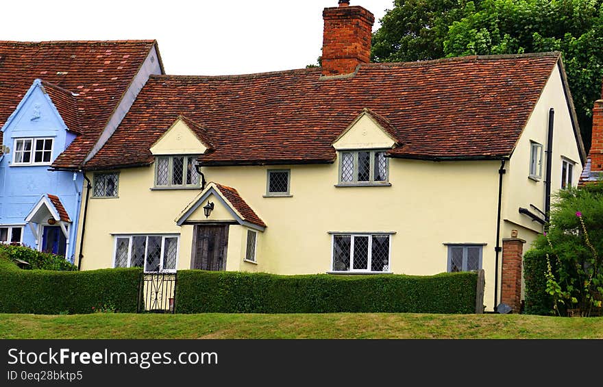 Green Grass Lawn Near White and Brown Painted House at Daytime