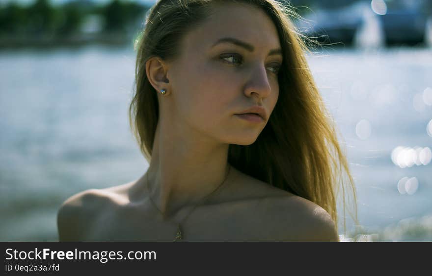 Closeup Photography of Woman With Gold Necklace Near Body of Water during Daytime