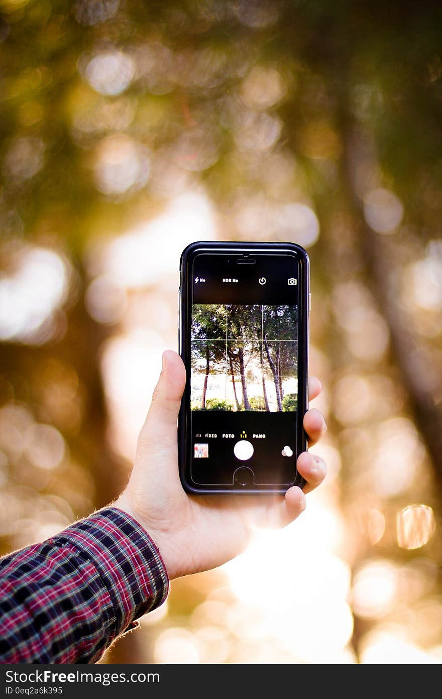 Hand holding smartphone with camera on touchscreen outdoors. Hand holding smartphone with camera on touchscreen outdoors.