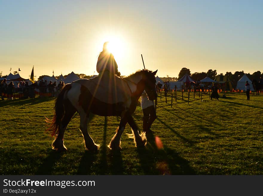 Person Riding on Horse Under Cloudy Sky during Daytime