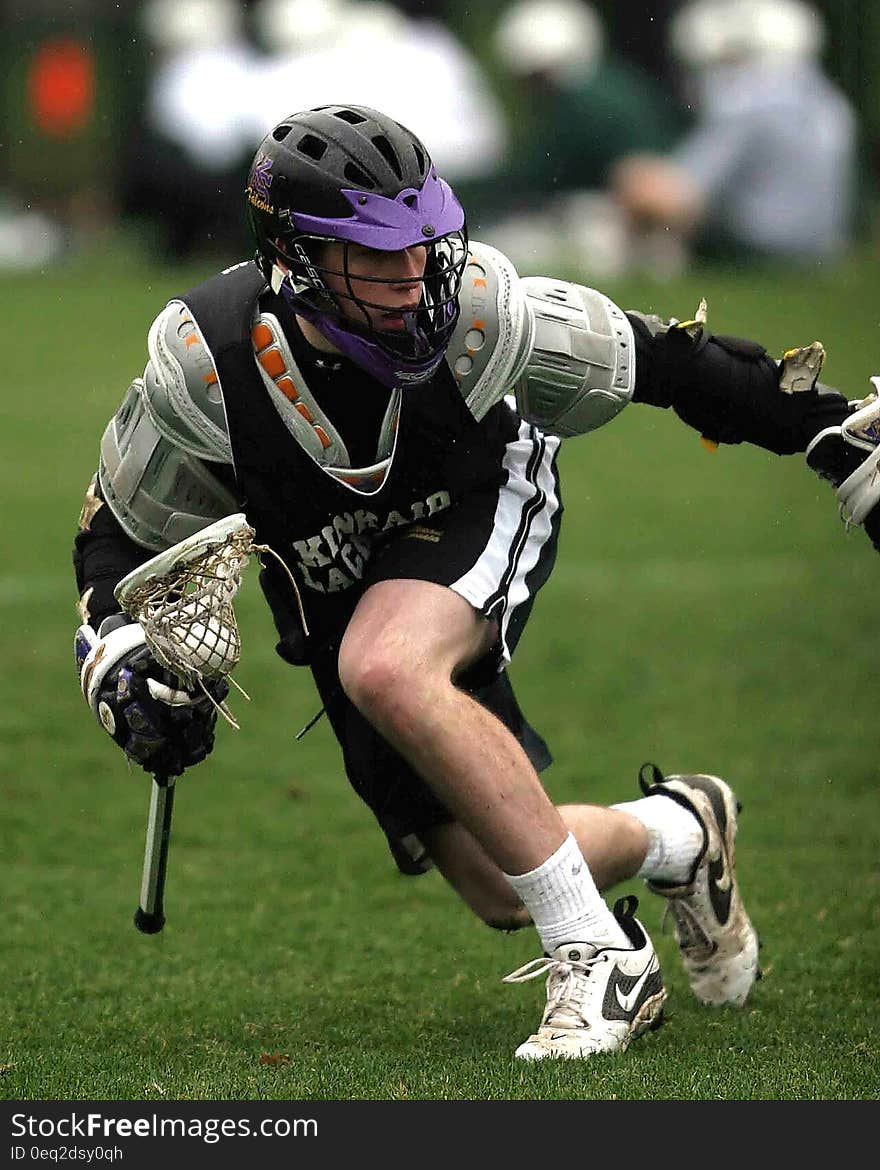 Person in Black Sports Jersey Playing Lacrosse