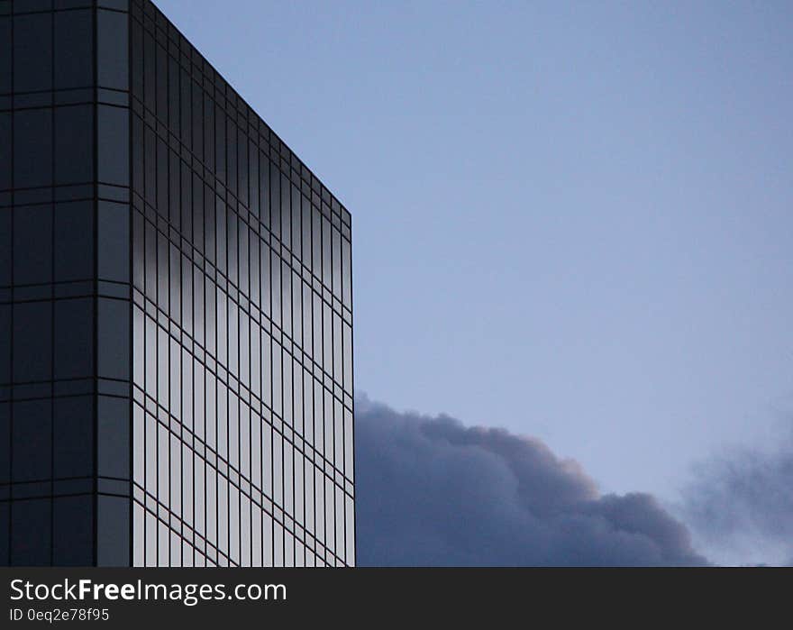 Exterior of high rise modern office building with sky and cloudscape background.