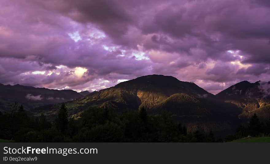 Brown Mountain Under Cloudy Sky during Sunset