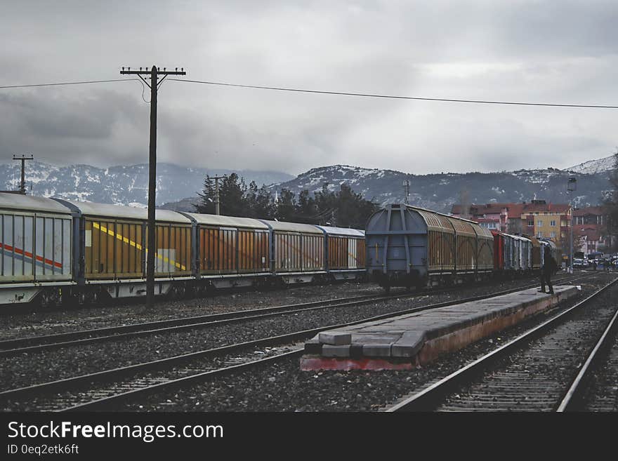 Train Running on Train Track Under Gray Sky at Daytime