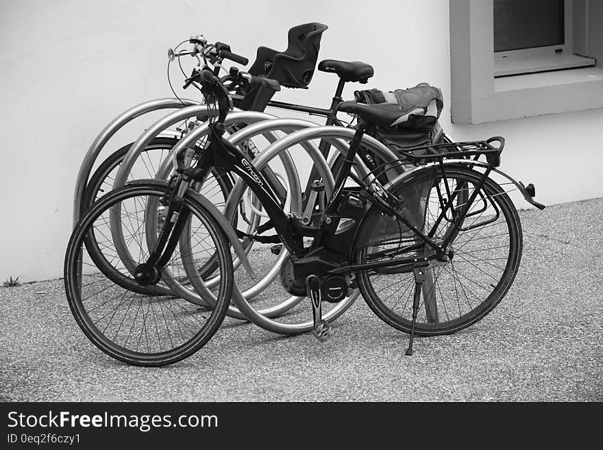 Black and Grey Bicycle Park Beside Wall