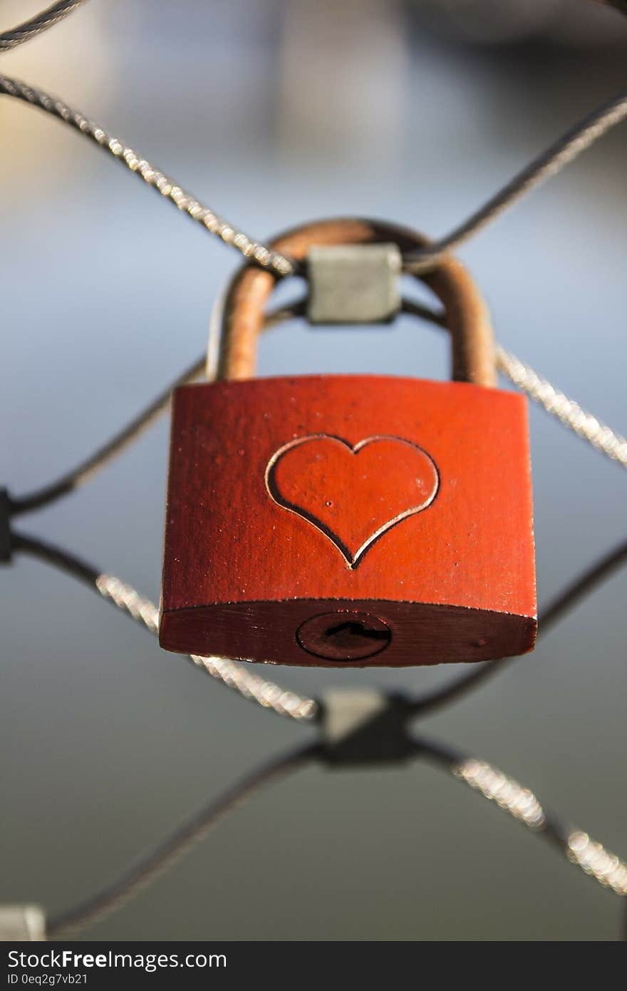 A lock with and engraved heart on a fence. A lock with and engraved heart on a fence.