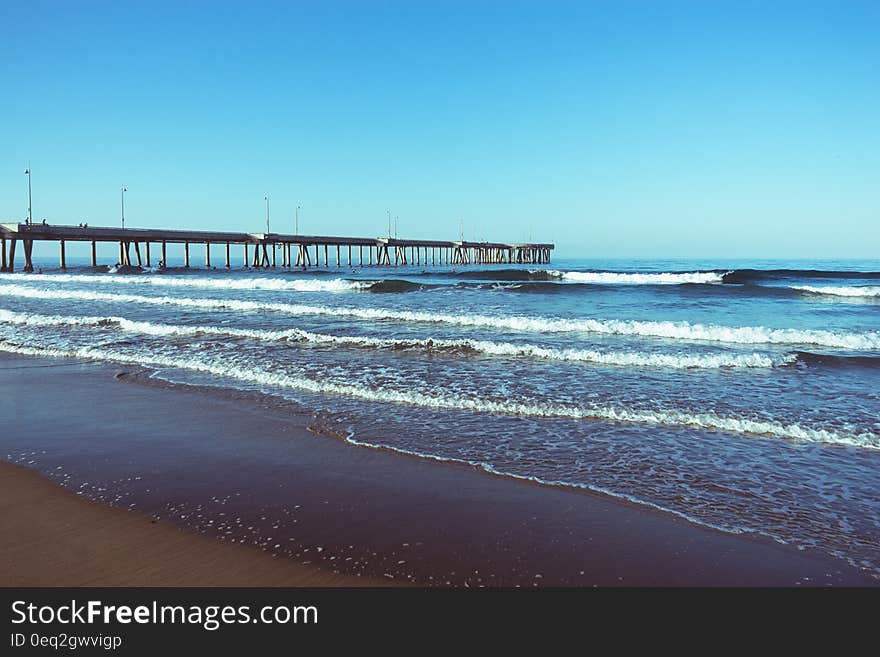 A sandy beach and a pontoon in shallow sea water. A sandy beach and a pontoon in shallow sea water.