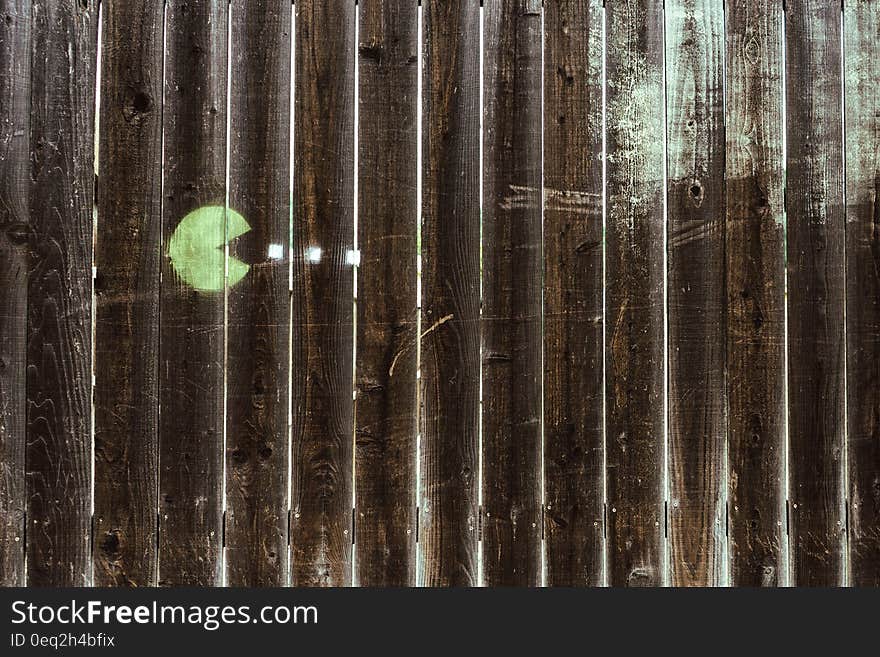 Light green Pacman drawing on a wooden fence. Light green Pacman drawing on a wooden fence.