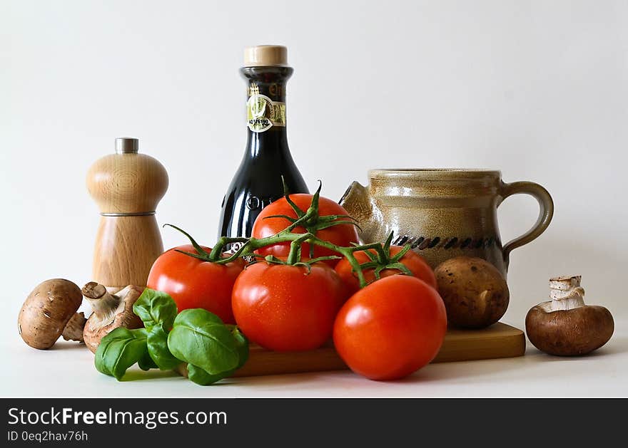 Mushrooms, basil, tomatoes and kitchen accessories on a white background. Mushrooms, basil, tomatoes and kitchen accessories on a white background.