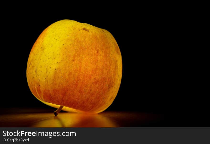 Lighted Apple over Black Surface