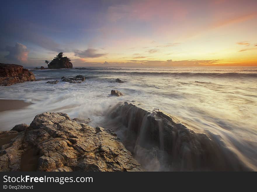 Brown and Grey Rock Near Sea during Sunrise