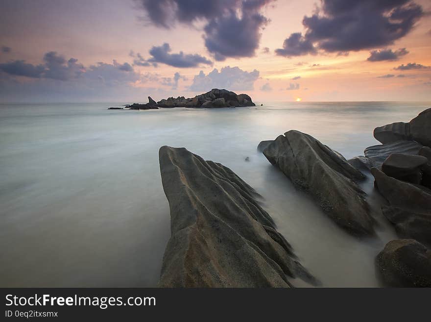 Rock Near a White Foggy Area Under an Orange Sky