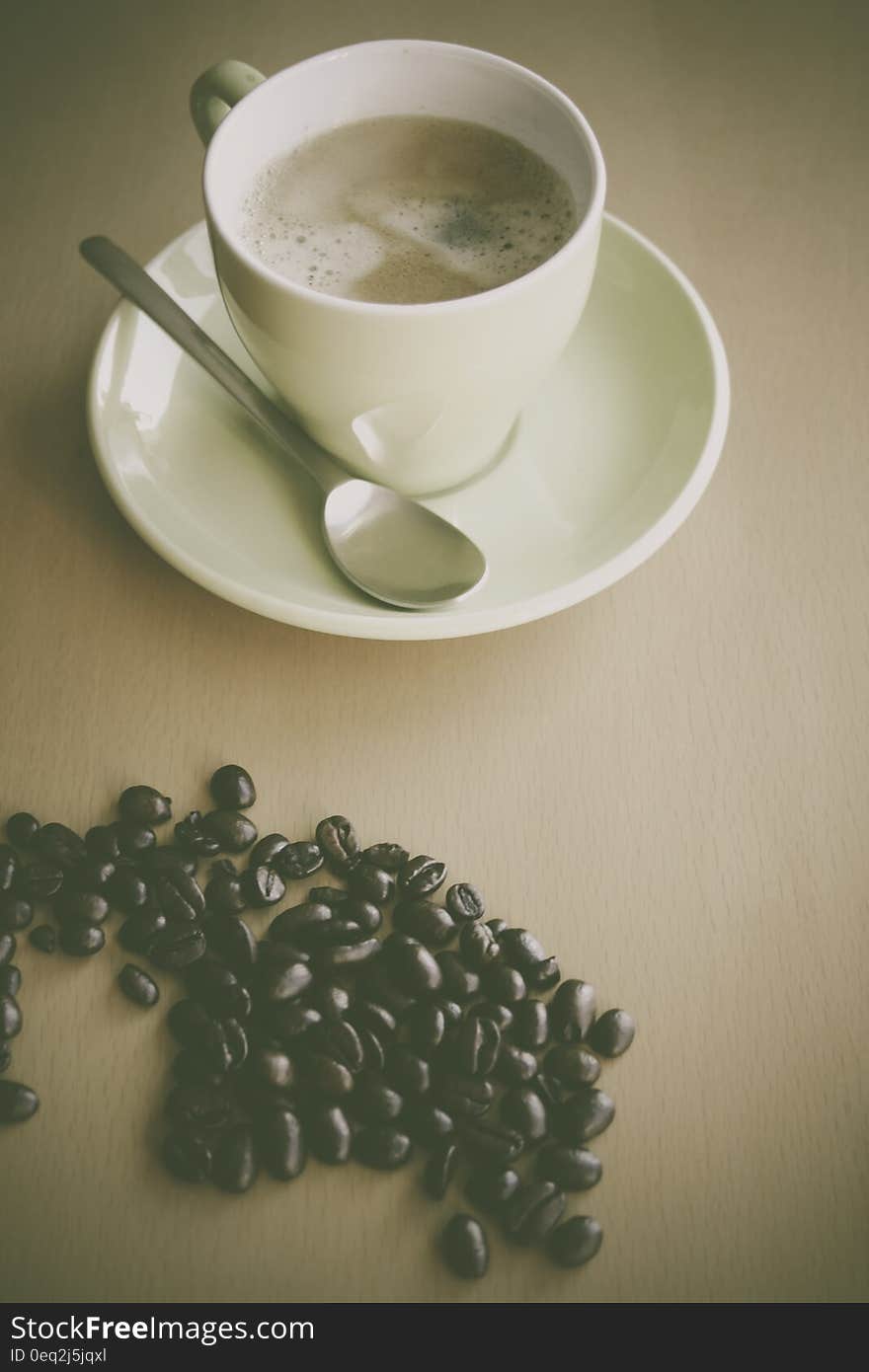 White Ceramic Coffee Mug Beside Silver Teaspoon on White Ceramic Plate