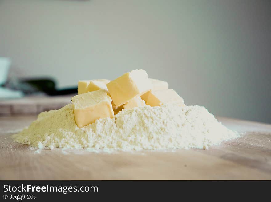 Yellow Pastry on White Powder on Brown Wooden Table