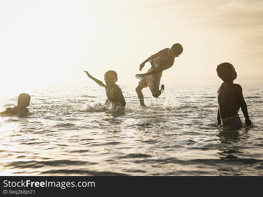 4 Person Playing in Ocean during Daytime