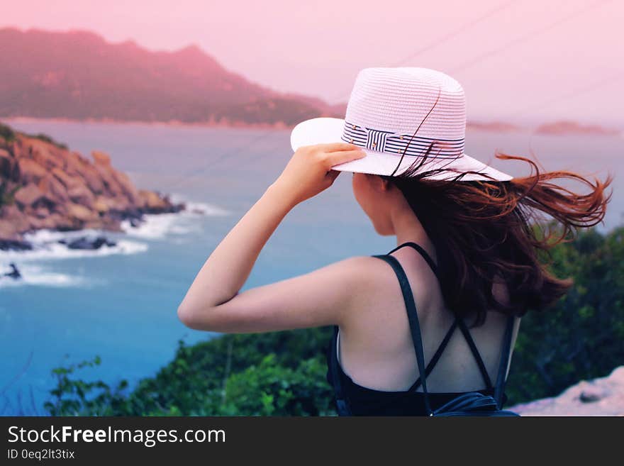 Wman Holding Wricker Shade Hat on Ocean View