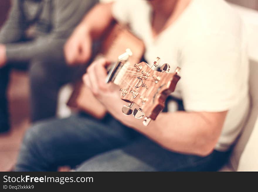 A close up of a man playing an acoustic guitar. A close up of a man playing an acoustic guitar.