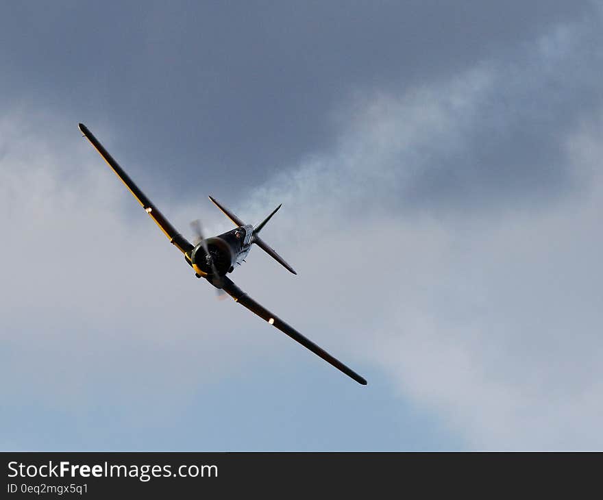 Black Airplane Under Dark Cloud Sky