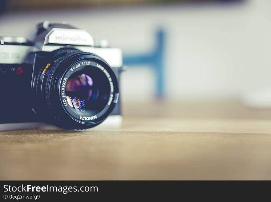 Shallow Focus Photo of Dslr Camera on Brown Wooden Table