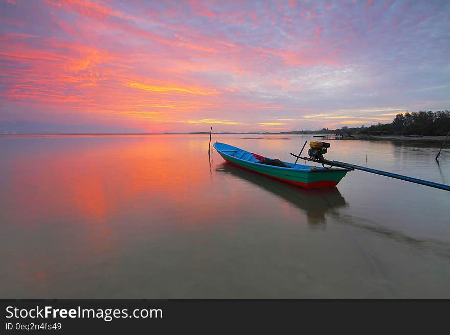 A boat floating on sea surface at sunset. A boat floating on sea surface at sunset.