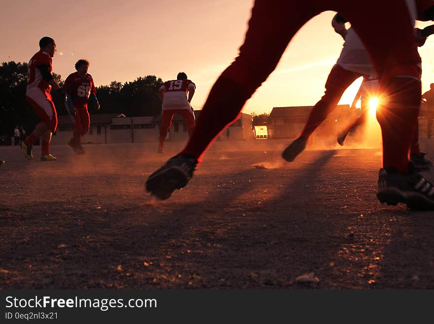 A group of men training for American football at sunset. A group of men training for American football at sunset.