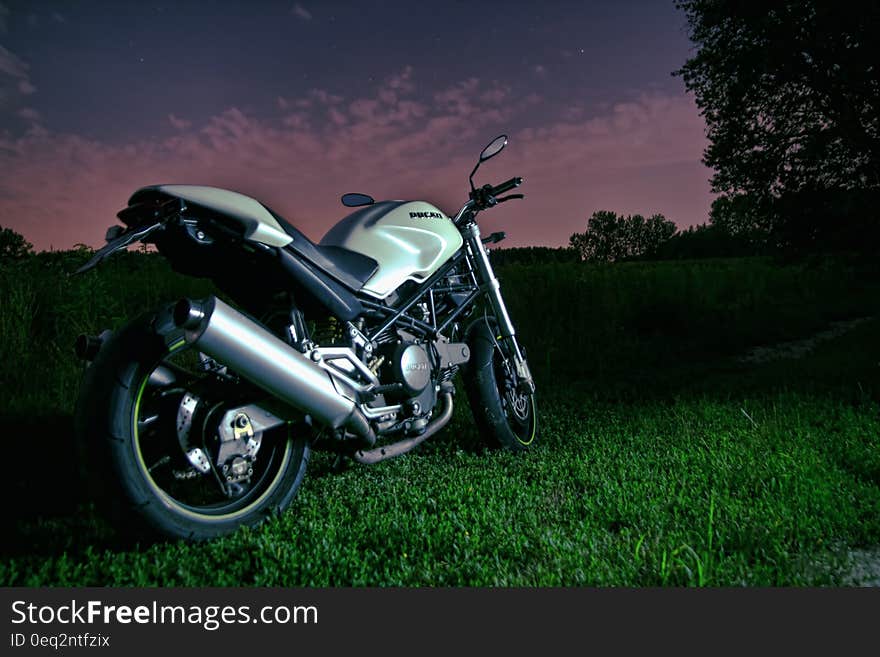 A motorbike resting on green grass. A motorbike resting on green grass.