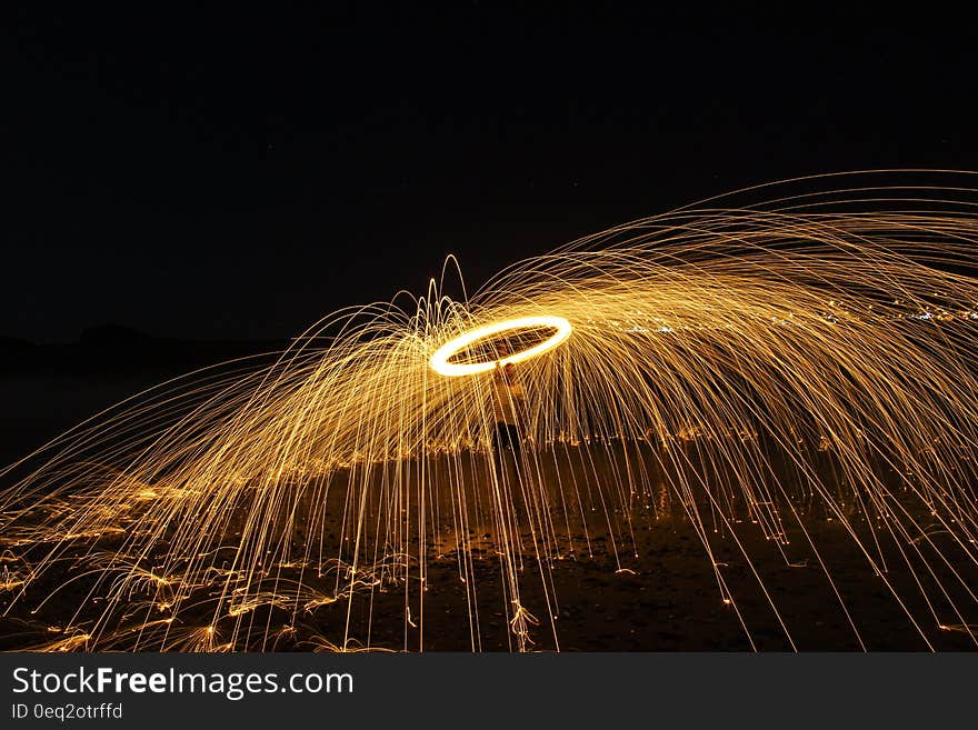 A long exposure of a burning fire ring with streaks caused by sparks.