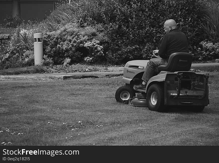 Man in Black Polo Shirt Riding Riding Mower