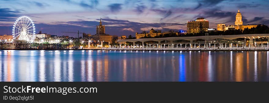 A panoramic view of the Thames river bank in London at dusk.