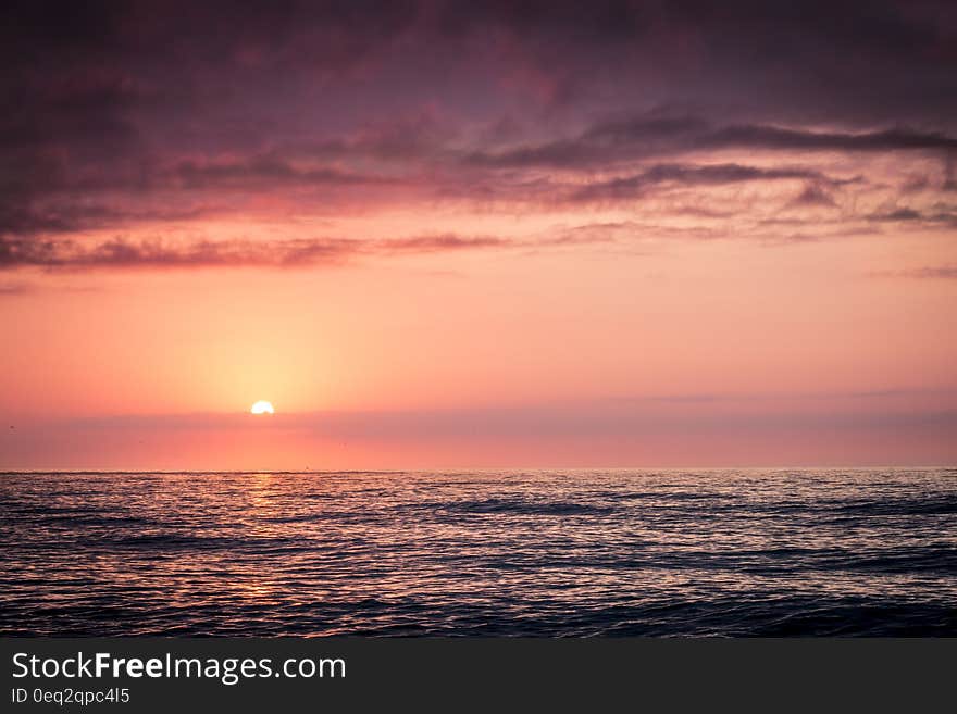 Sun setting over the horizon in open sea. Sun setting over the horizon in open sea.