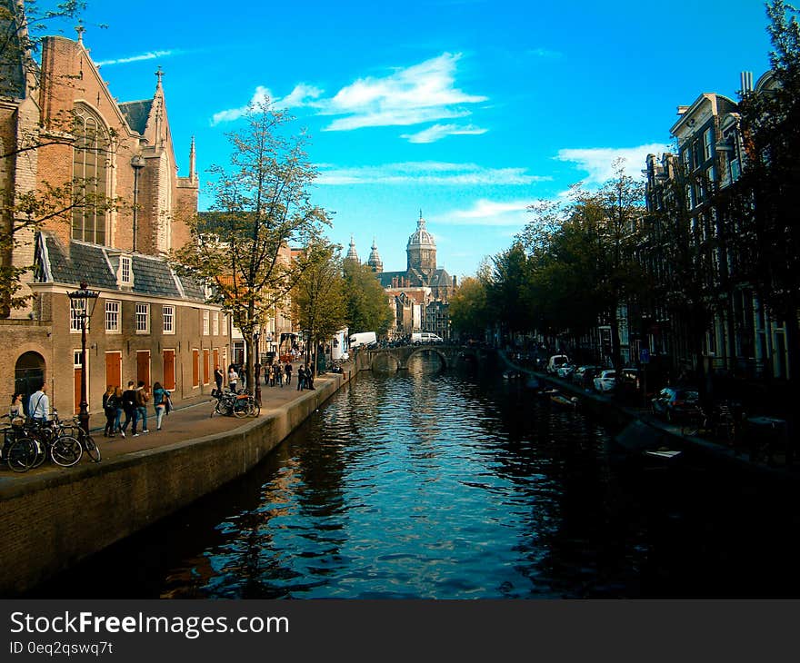 A canal in Amsterdam, people and buildings on its banks.