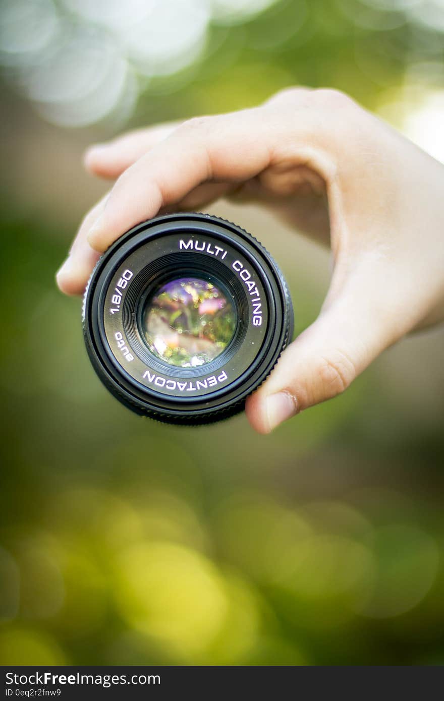 A close up shot of a hand holding a camera lens outdoor. A close up shot of a hand holding a camera lens outdoor.