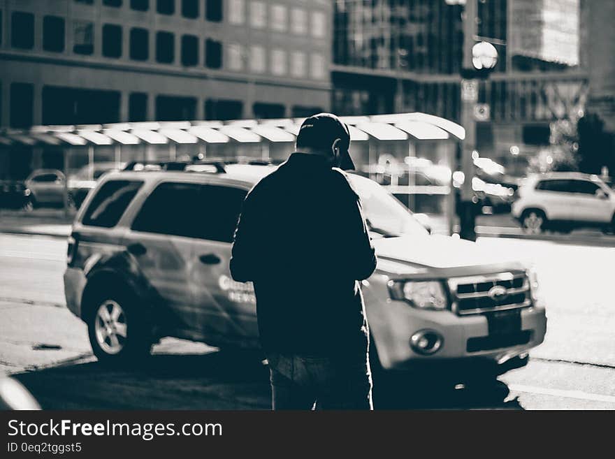 Grayscale Photography of Man Standing Near Suv during Daytime