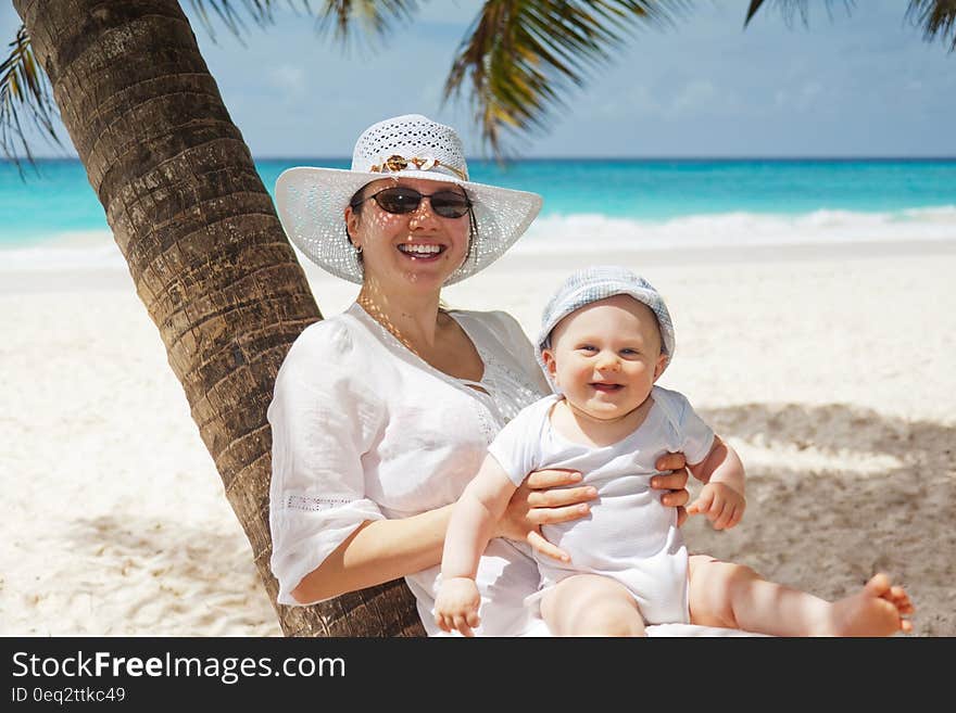 Woman Holding Infant on Beach