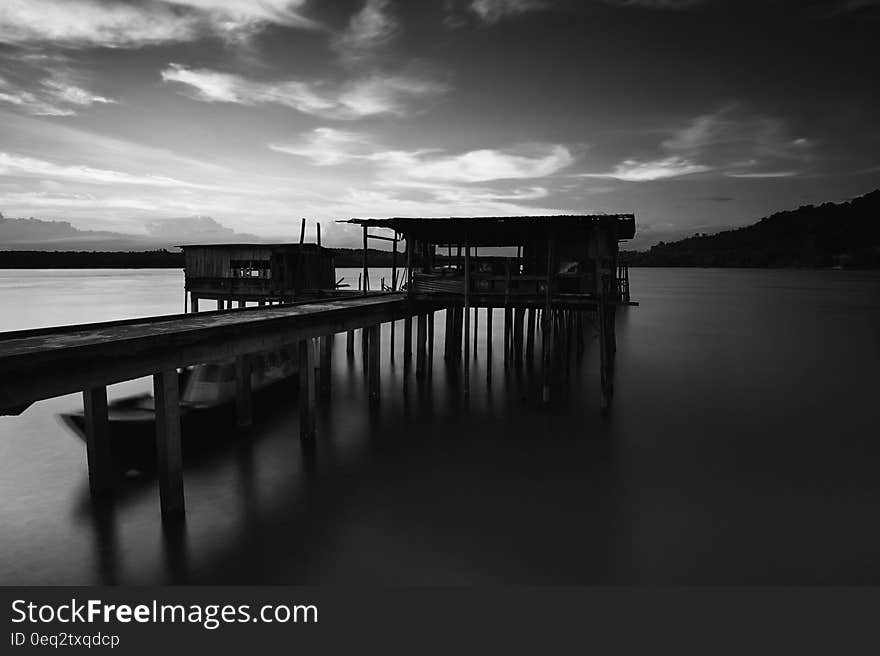 Greyscale Photo of Dock Near Mountains