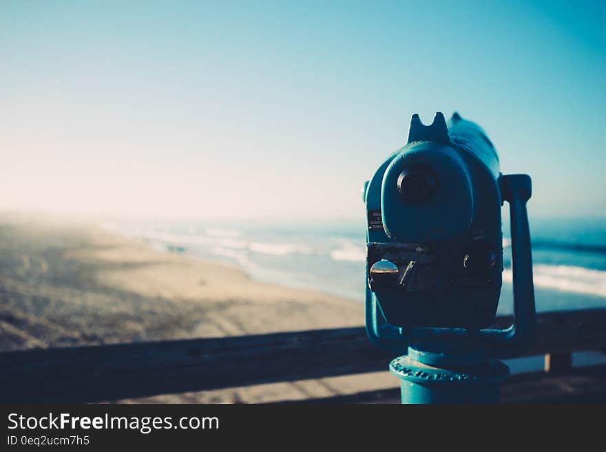 Public binocular telescope looking over beach and sea. Public binocular telescope looking over beach and sea.