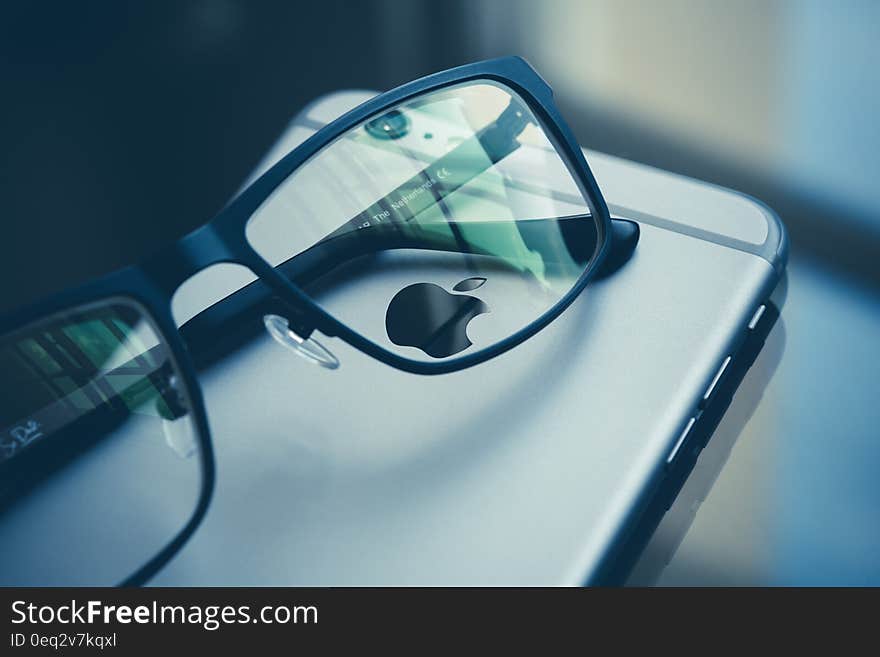 Eye glasses on iphone smartphone on the desk