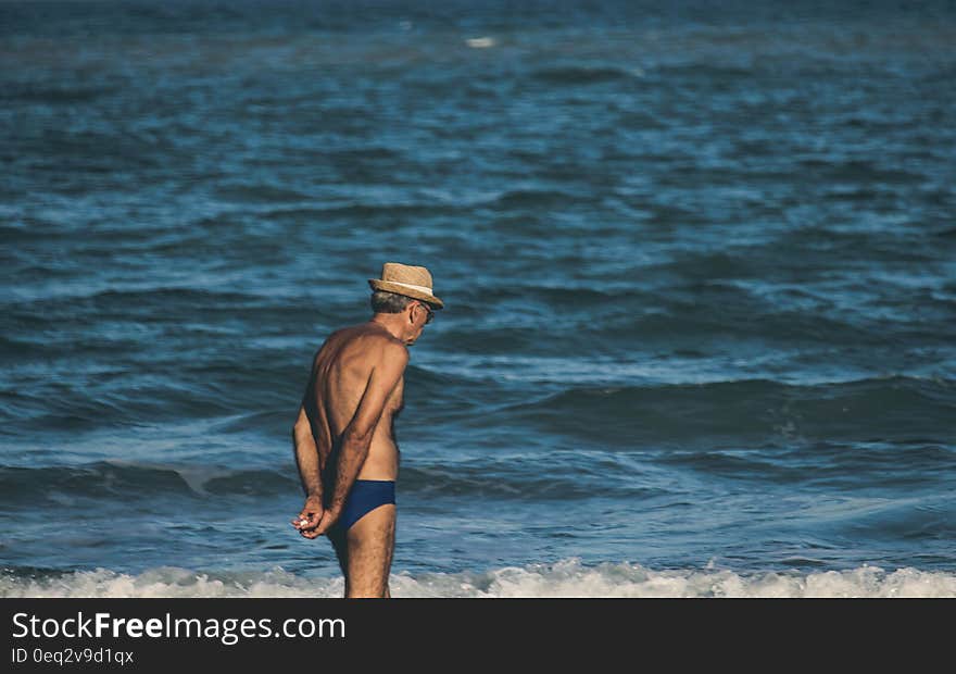 Elder man next to sea water on the beach. Elder man next to sea water on the beach