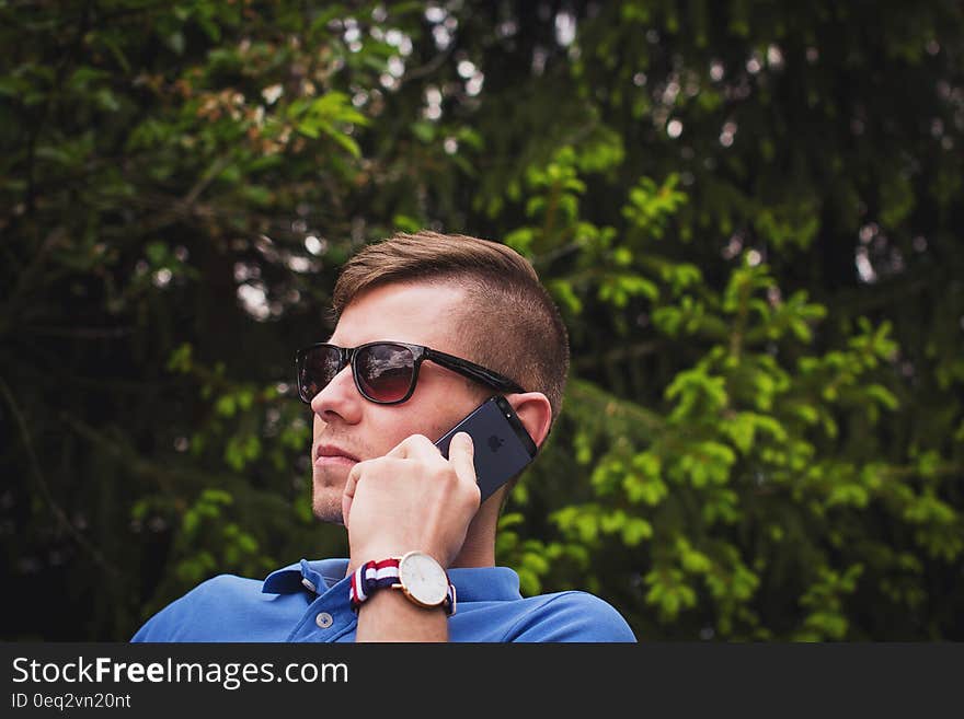 Young man talking on a mobile phone outdoors. Young man talking on a mobile phone outdoors.