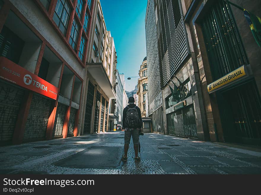 Man standing with photo camera in the street seen from the back. Man standing with photo camera in the street seen from the back