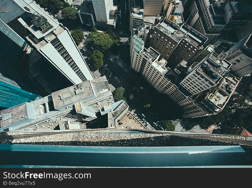 View from the top of a high rise building looking down onto streets and urban architecture.