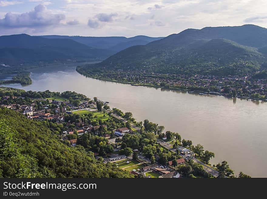 Areal Photo of Building Across Sea and Mountain during Daytime