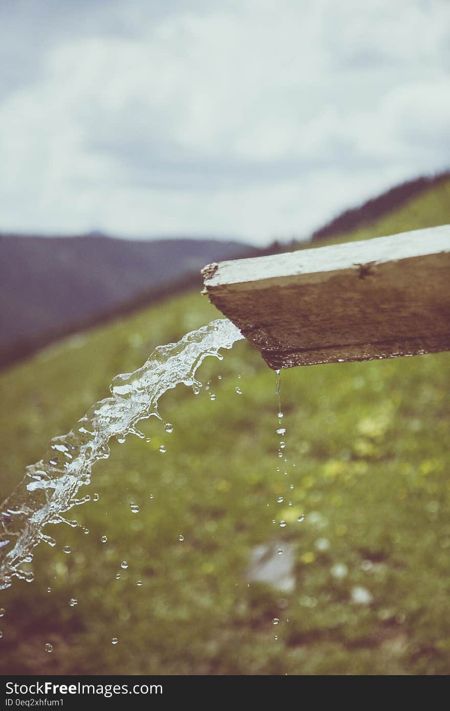 Water Pouring Thru Brown Wooden Cut Out Wood during Daytime