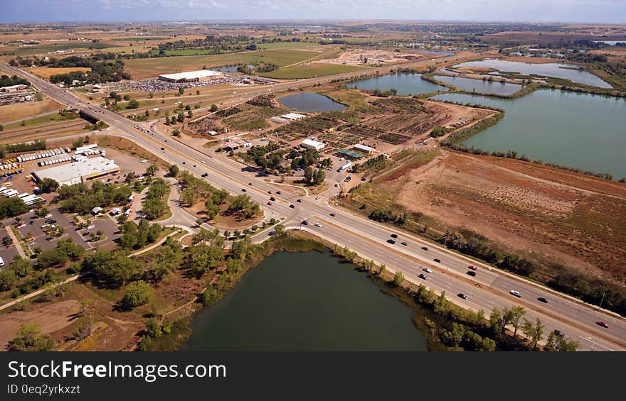 Aerial Photography of an Open Road With Cars Near City and Lake during Daytime