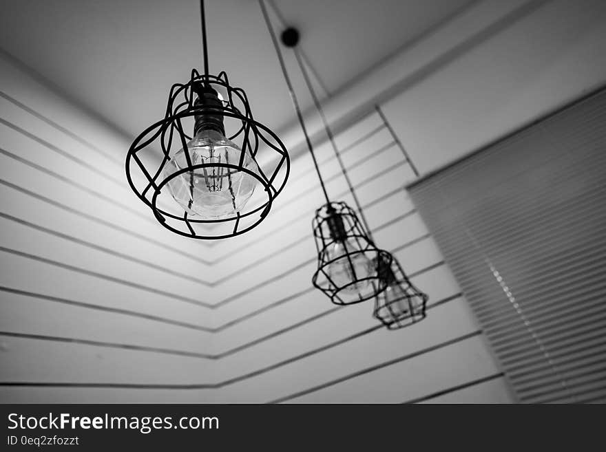 Black Steel Framed Round Pendant Lamp Indoors Near Window Blinds on Grayscale