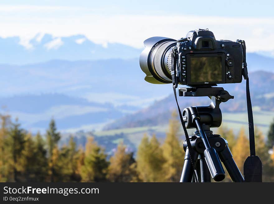 Black Dslr Camera Mounted on Black Tripod