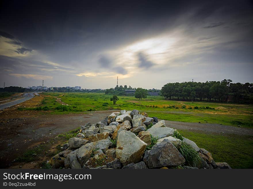 Stratus Clouds Above Green Grass and Beige Stones